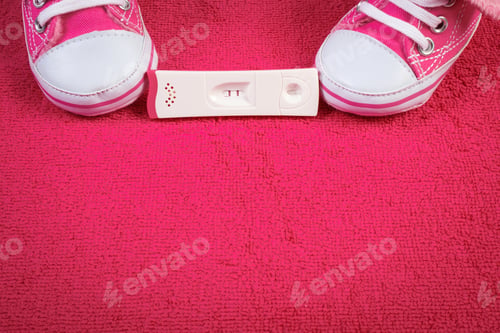 Preview: Pregnancy Test With Positive Result And Baby Shoes, Concept Of Extending Family And Expecting For