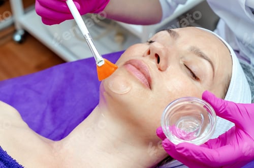 Preview: Beautician Applies Gel Cream On The Face Of Female Patient In Beauty Salon. Preparation For