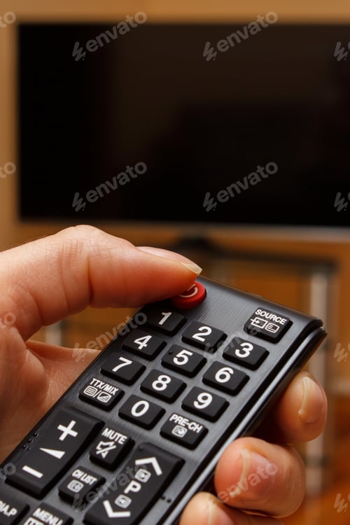 Preview: Hand Holding Infrared Remote Control For Television And Tv Screen In Background, Choosing Program