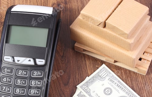 Preview: Payment Terminal, Currencies Dollar And Small Wrapped Boxes On Wooden Pallet, Paying For Products