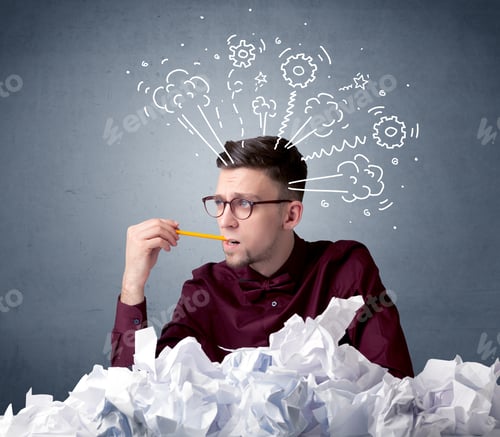 Preview: Young Businessman Sitting Behind Crumpled Paper With Drawings Of Gears And Steam Over His Head