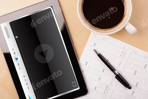 Preview: Workplace With Tablet Pc Showing Media Player And A Cup Of Coffee On A Wooden Work Table Close-Up