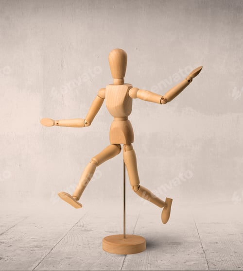 Preview: Wooden Mannequin Posed In Front Of A Greyish Background