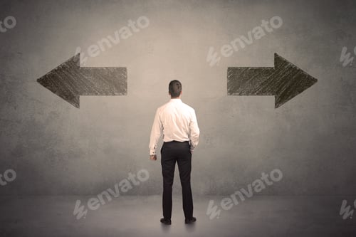 Preview: Business Man Taking A Decision While Standing In Front Of Two Grungy Arrows On Wall Concept