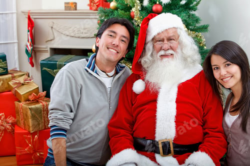 Preview: Couple With Santa Smiling Next To A Christmas Tree
