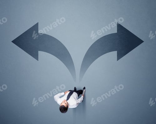 Preview: Young Smart Businessman Standing In Front Of Two Arrows Potinting To Different Ways Contemplating A