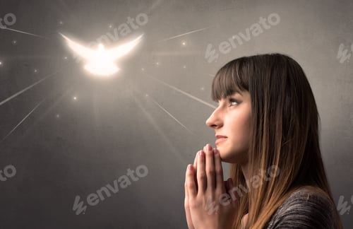 Preview: Young Woman Praying On A Grey Background With A Sparkling Bird Above Her
