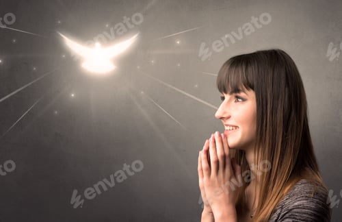 Preview: Young Woman Praying On A Grey Background With A Sparkling Bird Above Her