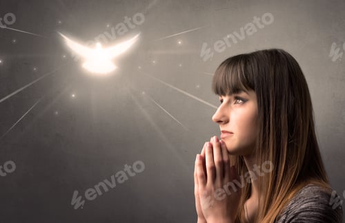 Preview: Young Woman Praying On A Grey Background With A Sparkling Bird Above Her