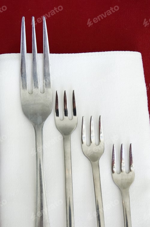 Preview: Large Dinner Fork And Three Smaller Forks On Red And White Linen