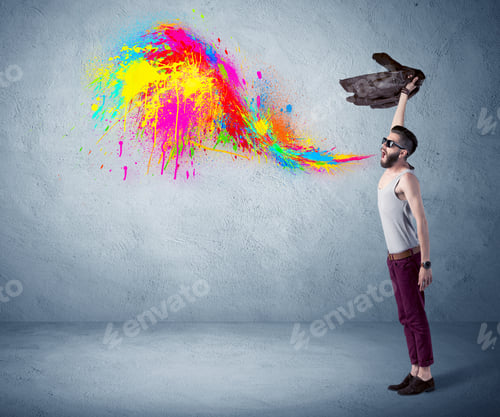 Preview: A Funny Hipster Person In Casual Urban Clothing Shouting Bright Colorful Paint On City Wall Concept