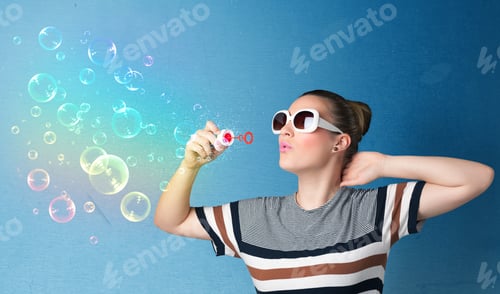 Preview: Pretty Lady Blowing Big Colorful Bubbles On Blue Background