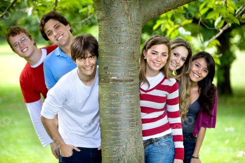 Preview: Casual Group Of Friends Smiling Outdoors By A Tree