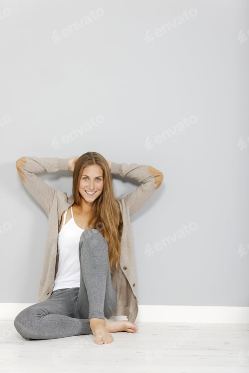 Preview: Attractive Young Woman Sitting On The Floor At Home Relaxing
