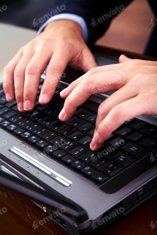 Preview: Business Man Typing On A Laptop Computer In An Office