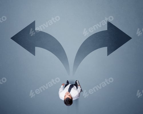 Preview: Young Smart Businessman Standing In Front Of Two Arrows Potinting To Different Ways Contemplating A