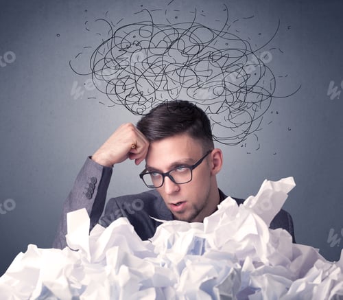 Preview: Young Businessman Sitting Behind Crumpled Paper With Scribbles Over His Head