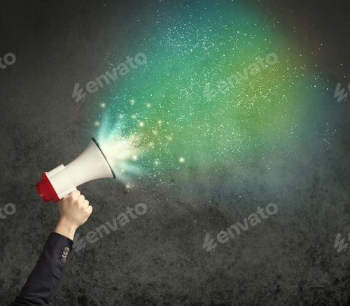 Preview: Caucasian Business Hand Holding Megaphone With White Sparkles On A Grunge Background