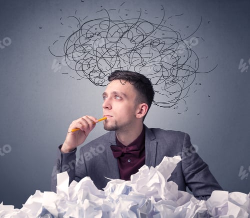 Preview: Young Businessman Sitting Behind Crumpled Paper With Scribbles Over His Head