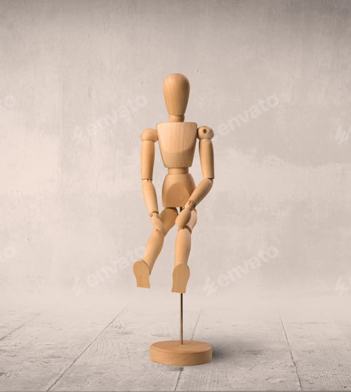 Preview: Wooden Mannequin Posed In Front Of A Greyish Background