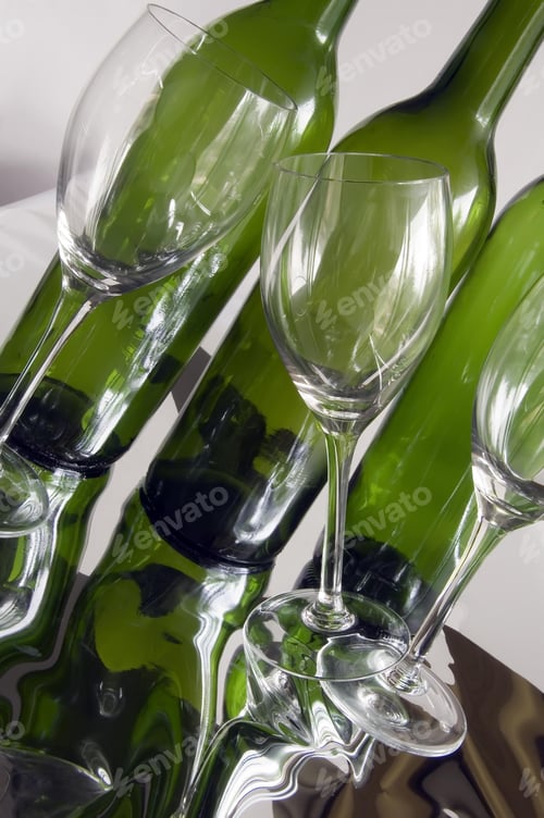 Preview: Three Wine Glasses, One Tilted, By Three Wine Bottles On Reflective Surface