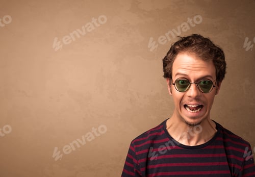 Preview: Portrait Of A Young Pretty Man With Sunglasses And Copyspace On Brown Background