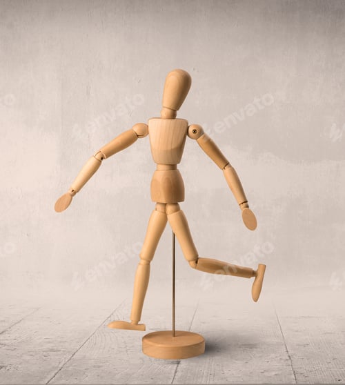 Preview: Wooden Mannequin Posed In Front Of A Greyish Background