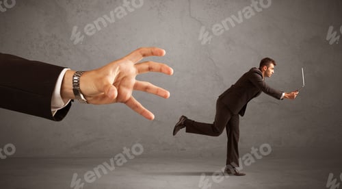 Preview: Young Miniature Businessman Running From A Big Hand With Grey Background