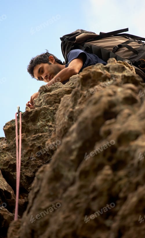 Preview: Male Climber On Top Of A Rock Setting Up His Grip And Ropes
