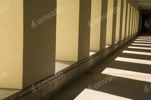 Preview: Interplay Of Sunlight And Shadow Along Passageway Outside University Building