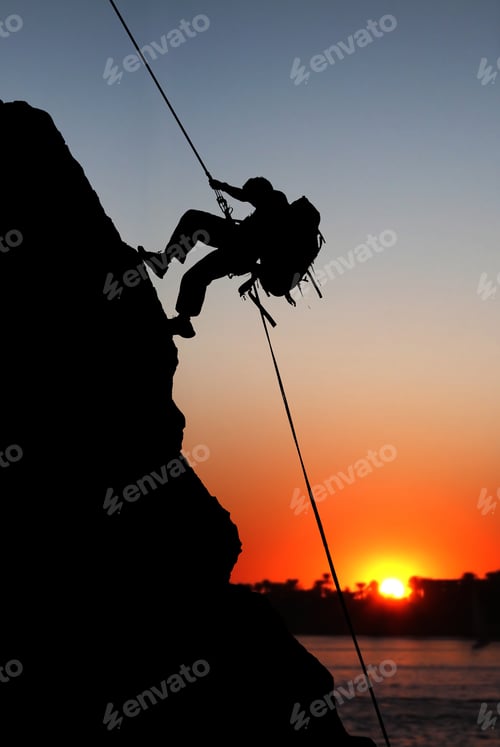 Preview: Rock Climber At Sunset Time Going Up A Mountain