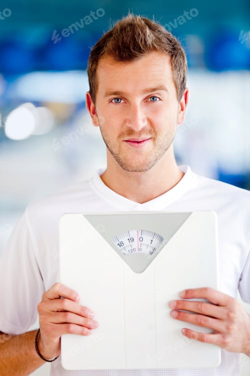 Preview: Man At The Gym Holding A Scale - Lose Weight Concepts