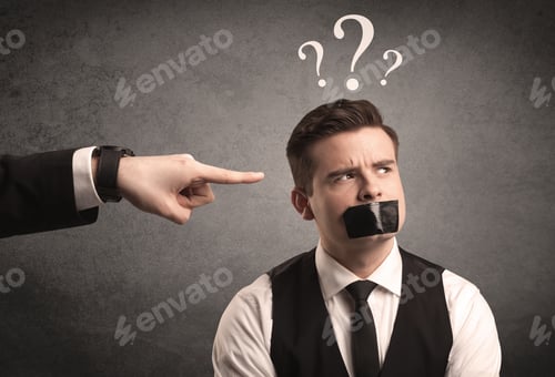 Preview: Caucasian Business Hand Pointing At Scared Employee With Big White Question Marks Above His Head