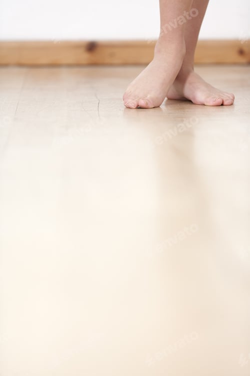 Preview: Woman'S Legs On Wooden Floor Against A White Wall Back Drop.