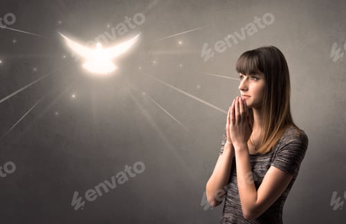 Preview: Young Woman Praying On A Grey Background With A Sparkling Bird Above Her