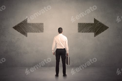 Preview: Business Man Taking A Decision While Standing In Front Of Two Grungy Arrows On Wall Concept