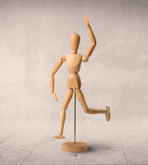 Preview: Wooden Mannequin Posed In Front Of A Greyish Background