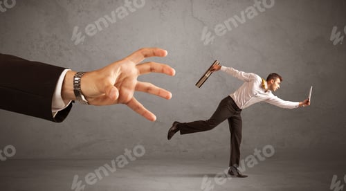 Preview: Young Miniature Businessman Running From A Big Hand With Grey Background