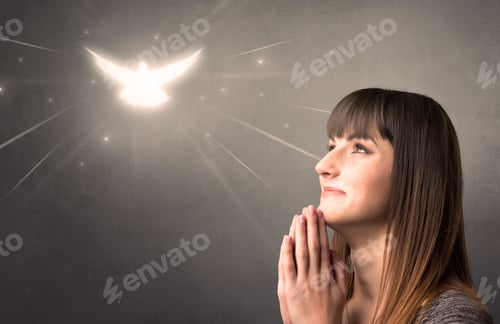 Preview: Young Woman Praying On A Grey Background With A Sparkling Bird Above Her