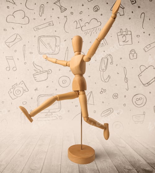Preview: Wooden Mannequin Posed In Front Of A Greyish Background With Mixed Media Scribbles Behind It