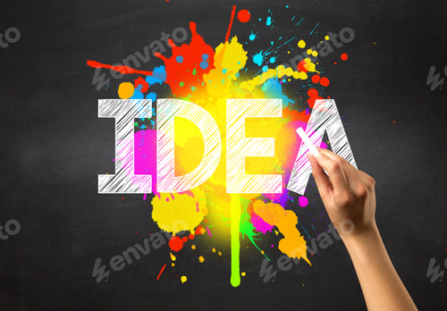 Preview: Female Hand Holding White Chalk In Front Of A Blackboard With Idea Written On It And A Colorful