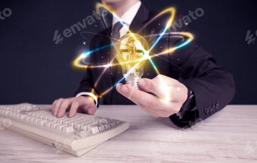 Preview: A Classy Businessman Holding A Colorful Light Bulb With Shining Circles In Front Of Dark Background