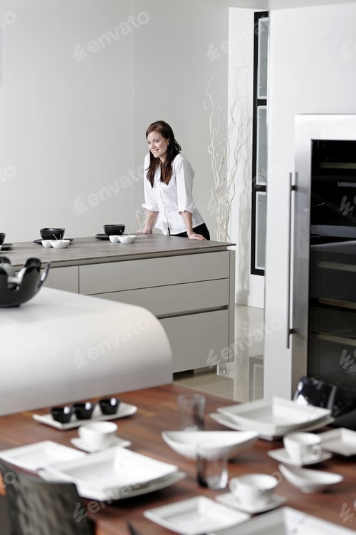 Preview: Beautiful Young Woman Relaxing In Her Elegant White Kitchen