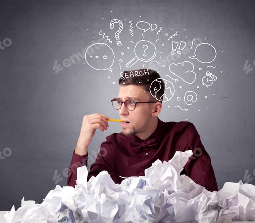 Preview: Young Businessman Sitting Behind Crumpled Paper With Mixed Doodles Over His Head