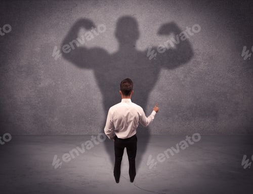 Preview: A Young Salesman Standing With His Back, Looking At His Musculous Shadow Reflecting On The Wall