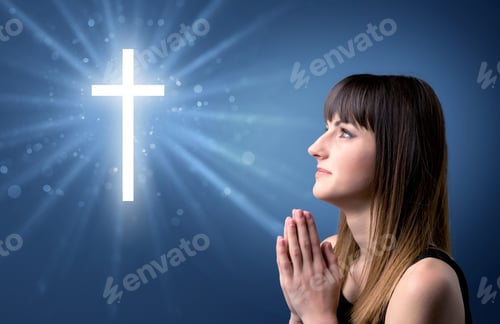 Preview: Young Woman Praying On A Blue Background With A Sparkling Cross Above Her