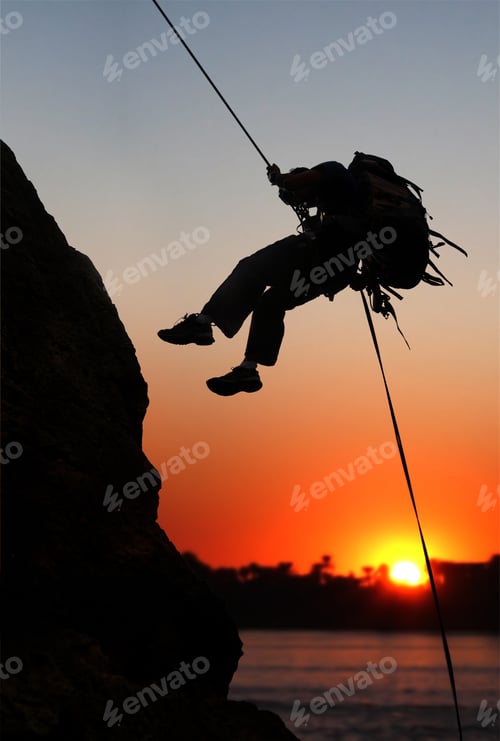 Preview: Rock Climber At Sunset Time Going Up A Mountain