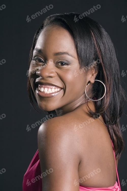 Preview: Young Black Woman In Pink Dress Looking To One Side With A Smile