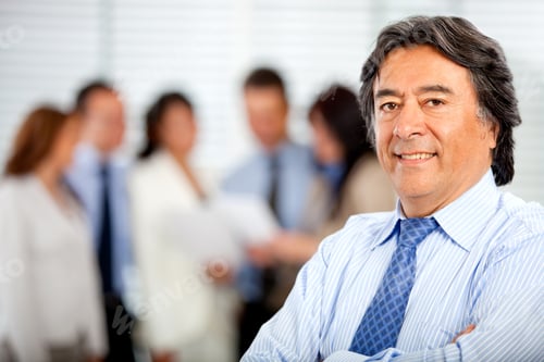 Preview: Business Man Smiling At The Office With His Team Behind Him