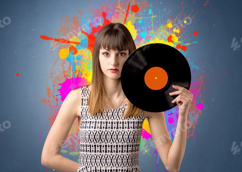 Preview: Young Lady Holding Vinyl Record On A Grey Background With Colorful Splashes Behind Her